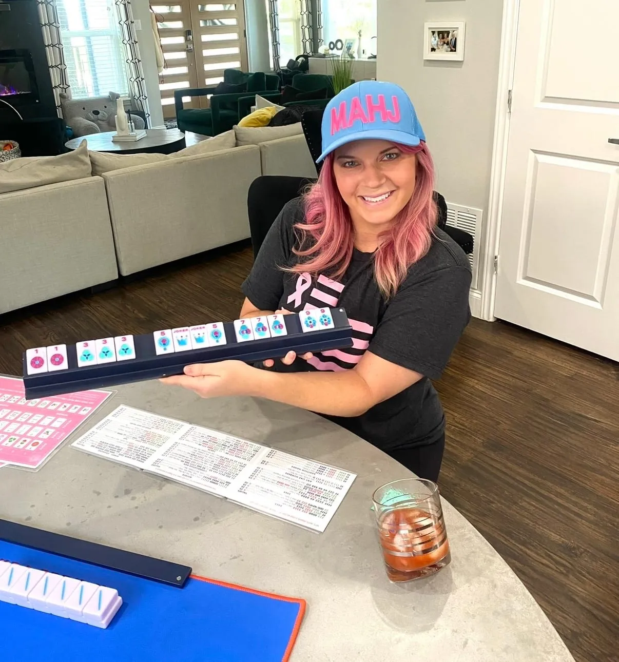 Courtney at the table mid-game, the mahjong card and colorful tiles laid out in front of her