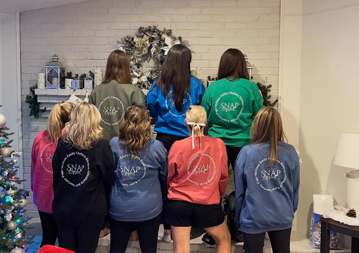 Friends in matching mahjong tee-shirts gathered together at an event