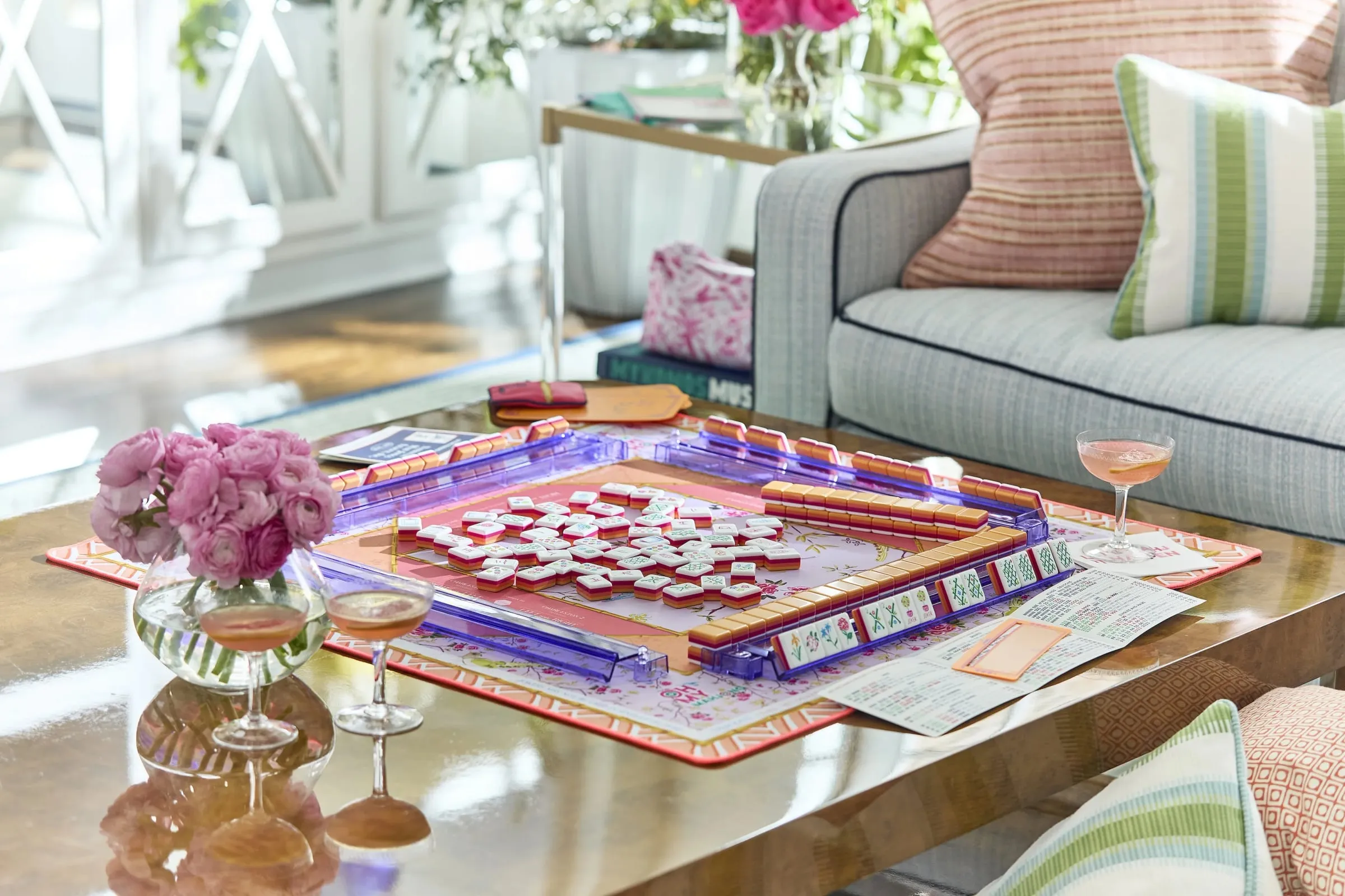 A game of American mahjong in play around a table, tiles and racks set out